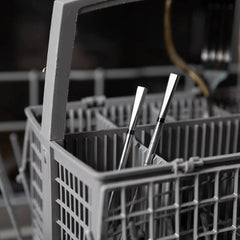 Dishwasher meater in rack with cutlery inside, blurred kitchen background